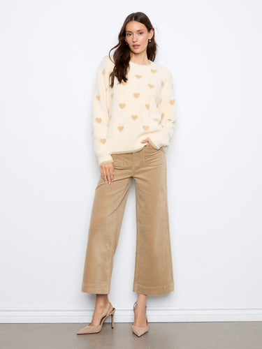 Cozy long-sleeve sweater adorned with delicate heart patterns, ideal for staying warm and stylish. By Charlie B.