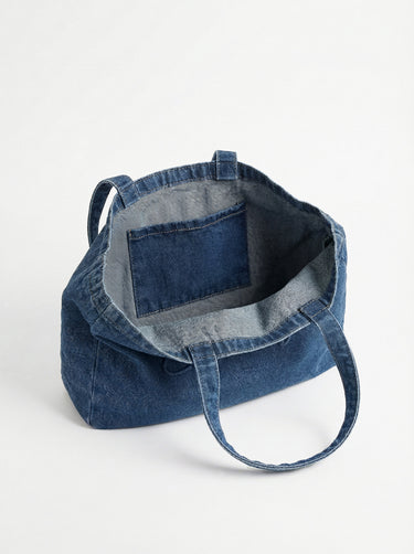Denim tote showcasing the embossed logo, offering ample space with a 16" length. Designed by Charlie B.