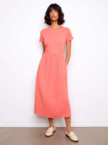 This dress features a classic crew neckline, offering a timeless look with its simple yet elegant design by Charlie B.