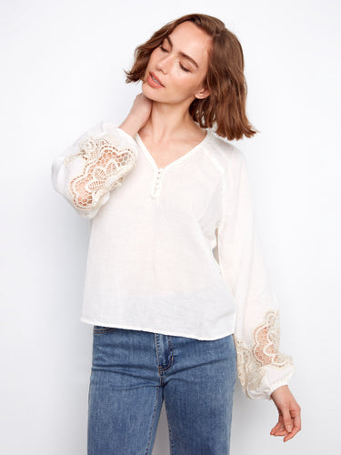 White linen blend blouse featuring a braided V-neck and intricate embroidered sleeves for a chic look by Charlie B.