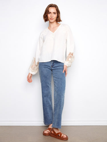 Elegant white blouse with decorative buttons and lace detailing on the balloon sleeves, perfect for any occasion by Charlie B.