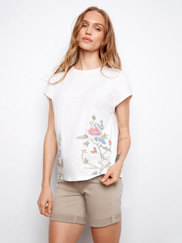 This white cotton tee boasts delicate floral embroidery on the sides by Charlie B.