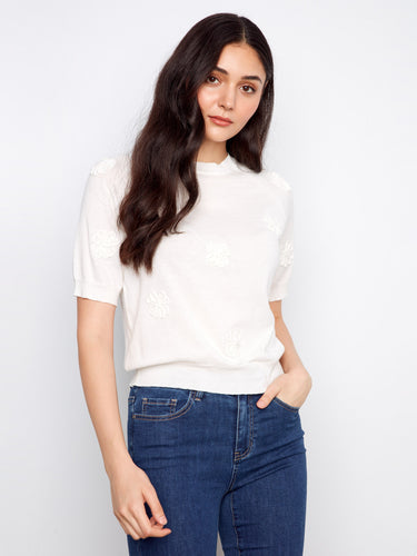 Stylish white knit top crafted from 100% cotton with delicate floral details for added charm by Charlie B.