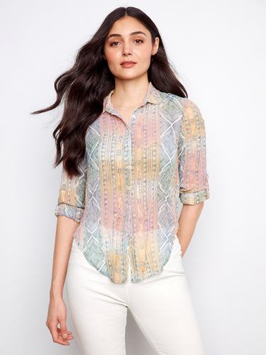 The shirt features a classic collar, perfect for versatile styling. Its elegant design is complemented by intricate patterns. By Charlie B.