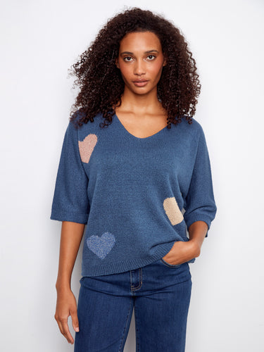 Blue sweater featuring a V-neck design and charming heart patterns, perfect for casual wear by Charlie B.