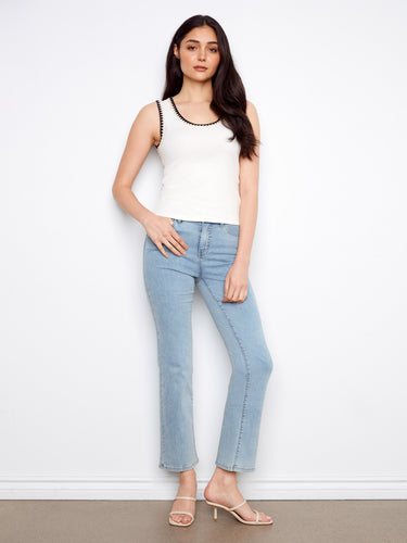 Chic white top with intricate crochet detail around the neckline, offering a modern sleeveless style by Charlie B.