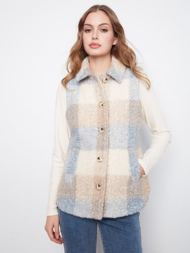 Plaid vest featuring a classic shirt collar, ideal for layering over casual outfits. Styled with a neutral palette. By Charlie B.