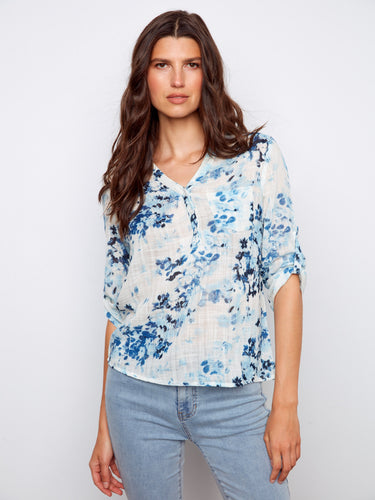 Floral blouse with a chic Henley neckline and soft blue pattern, perfect for casual outings. Crafted with care by Charlie B.