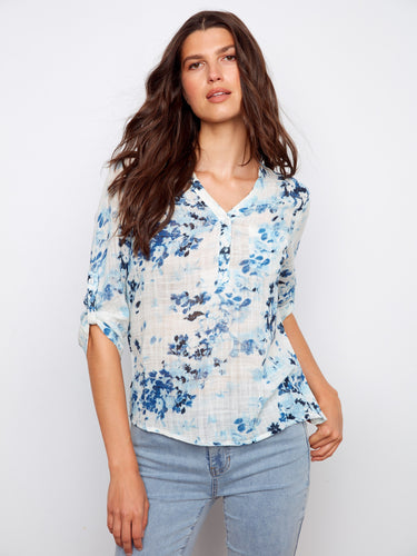 A charming floral blouse with adjustable roll-up sleeves for adaptable style and comfort in any season. Designed by Charlie B.