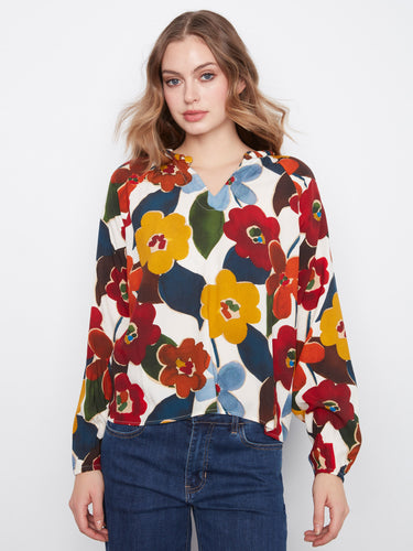 Floral blouse with a striking notch neckline, perfect for adding elegance to any outfit. Made from soft viscose fabric by Charlie B.