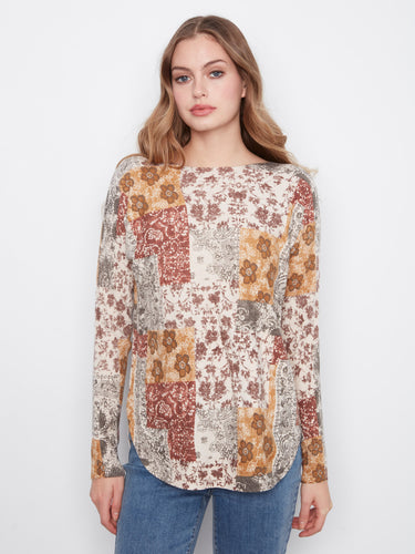 The sweater showcases a lovely boat neckline with a floral patchwork design, adding charm to any outfit by Charlie B.