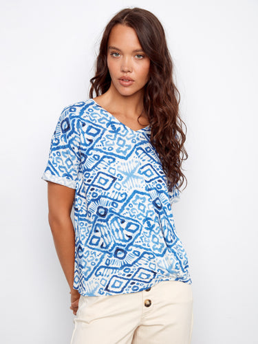 Chic blue patterned top showcasing short sleeves, perfect for casual wear. Paired with beige pants by Charlie B.