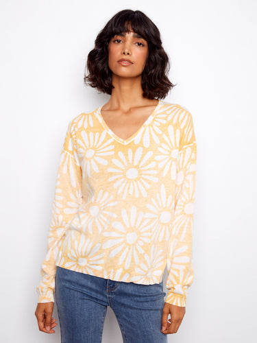 Charming sweater with a flattering V-neck, showcasing a cheerful floral pattern in soft hues. Perfect for casual outings. By Charlie B.