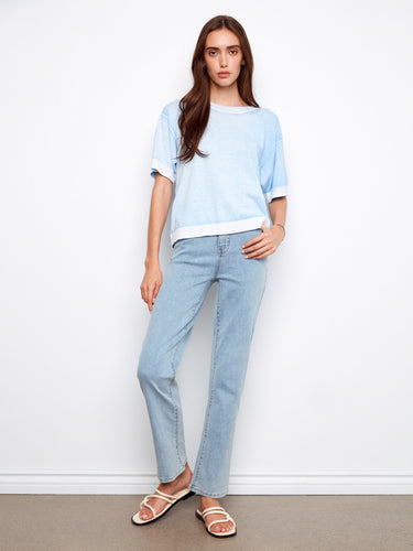 This blue sweater showcases a reverse print design, adding a unique touch to your wardrobe by Charlie B.