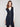 Elegant sleeveless vest in black, highlighted by its mid-thigh length and convenient patch pockets by Charlie B.