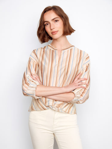 A chic striped pattern adorns the blouse, offering a timeless and fashionable look for any occasion. By Charlie B.