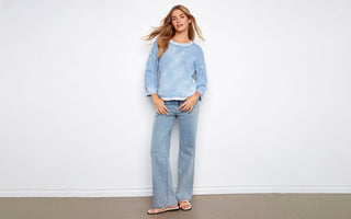 A washed blue pullover sweater paired with light-wash jeans, showing how to style a pullover sweater casually.