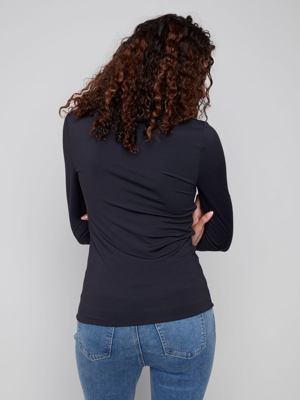 Black long-sleeve top with a crew neck, featuring a sleek fit and super stretchy fabric by Charlie B.