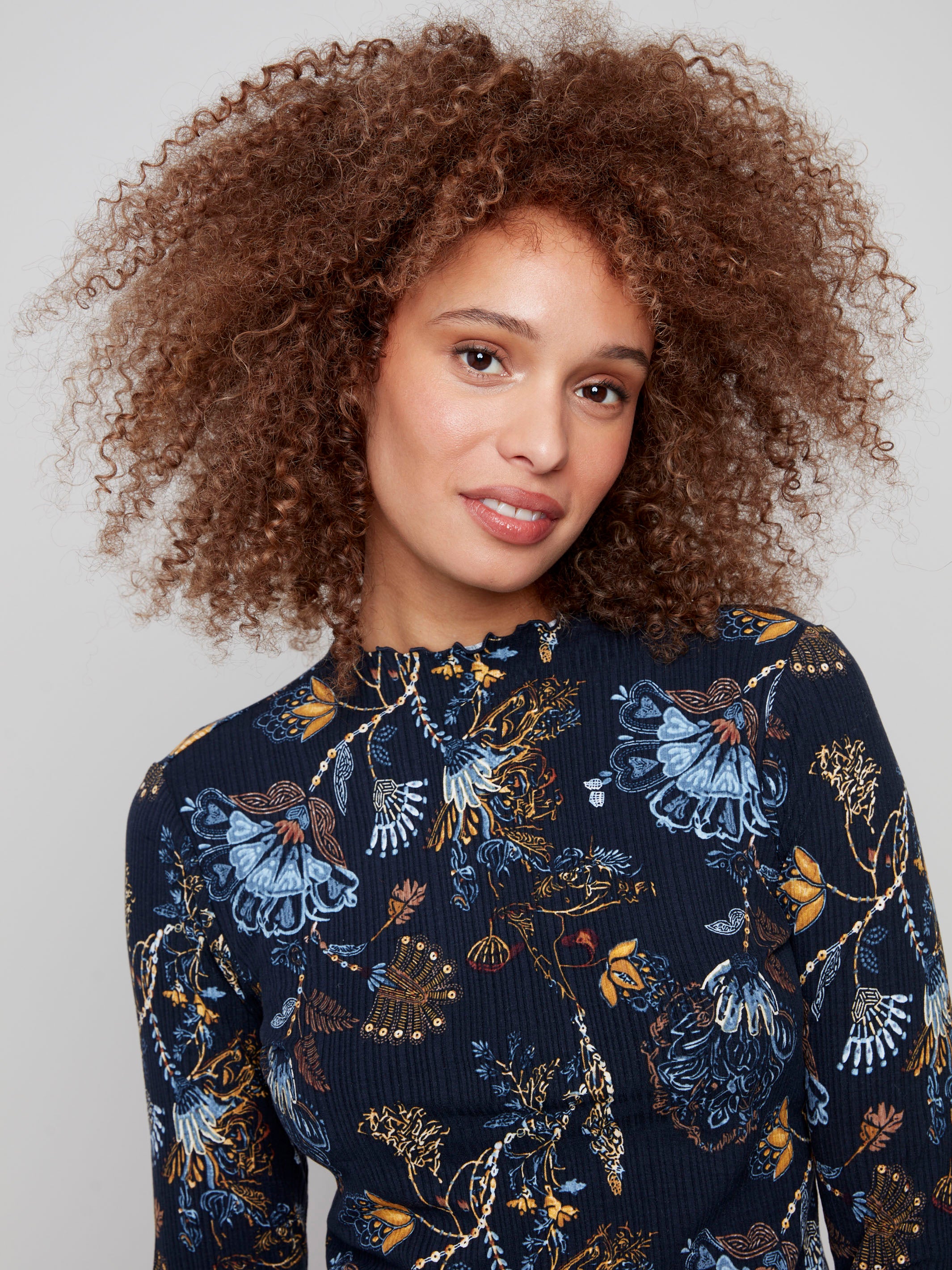 Chic mock neck top in a floral print, adorned with delicate ruffles that enhance its sophisticated style by Charlie B.