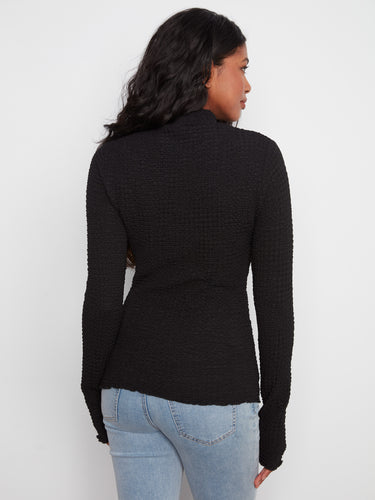 Chic black bubble knit top with an eye-catching lettuce-edge detail and mock neck design by Charlie B.