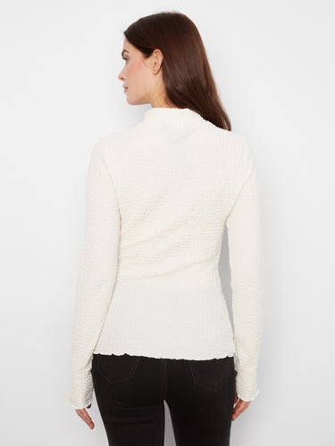The mock neck adds elegance while the bubble knit texture offers unique style. A must-have fashion item from Charlie B.