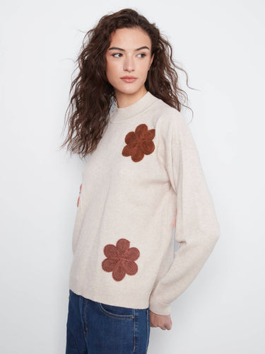 Chic sweater featuring ribbed cuffs and beautiful floral appliqué detailing for added flair by Charlie B.