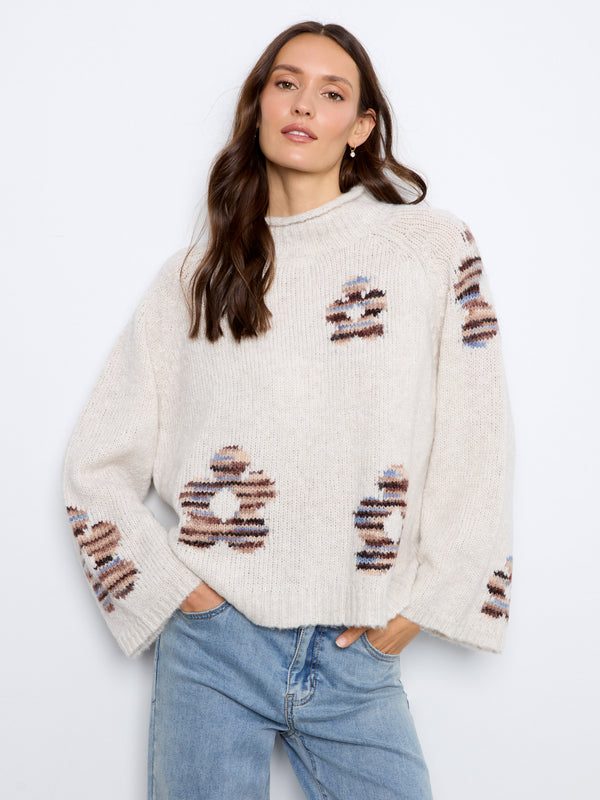 This cozy sweater features a stylish mock neck, offering both warmth and sophistication. By Charlie B.