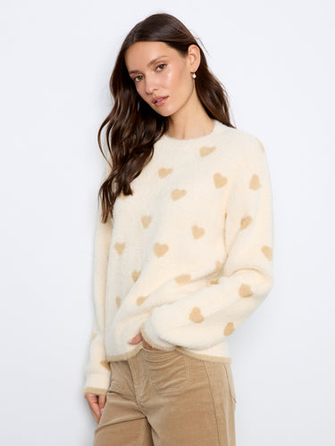 Chic sweater with intricate heart designs throughout, offering both comfort and style in cooler weather. By Charlie B.