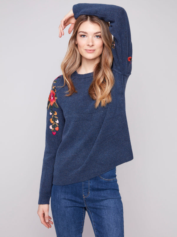 Stylish denim sweater featuring knit cuffs and vibrant floral embroidery for a chic look by Charlie B.