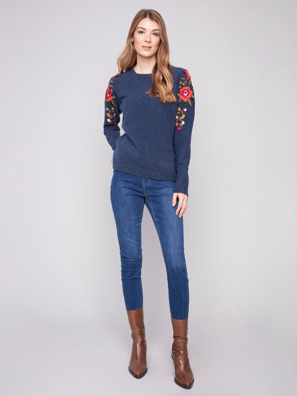 Floral embroidered sleeves on a heather denim sweater offer a unique fashion statement by Charlie B.