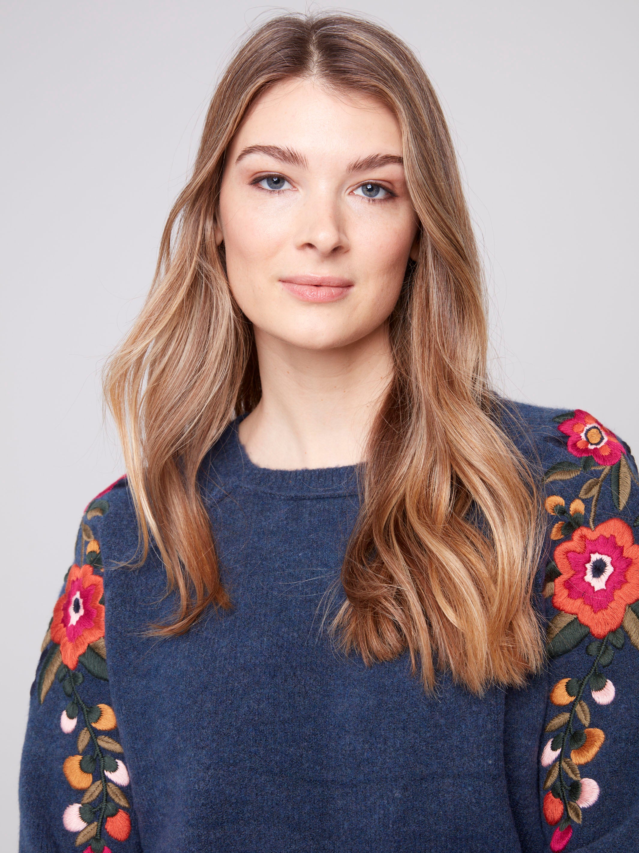 Elegant crew neckline complements the detailed floral sleeves of this denim sweater by Charlie B.