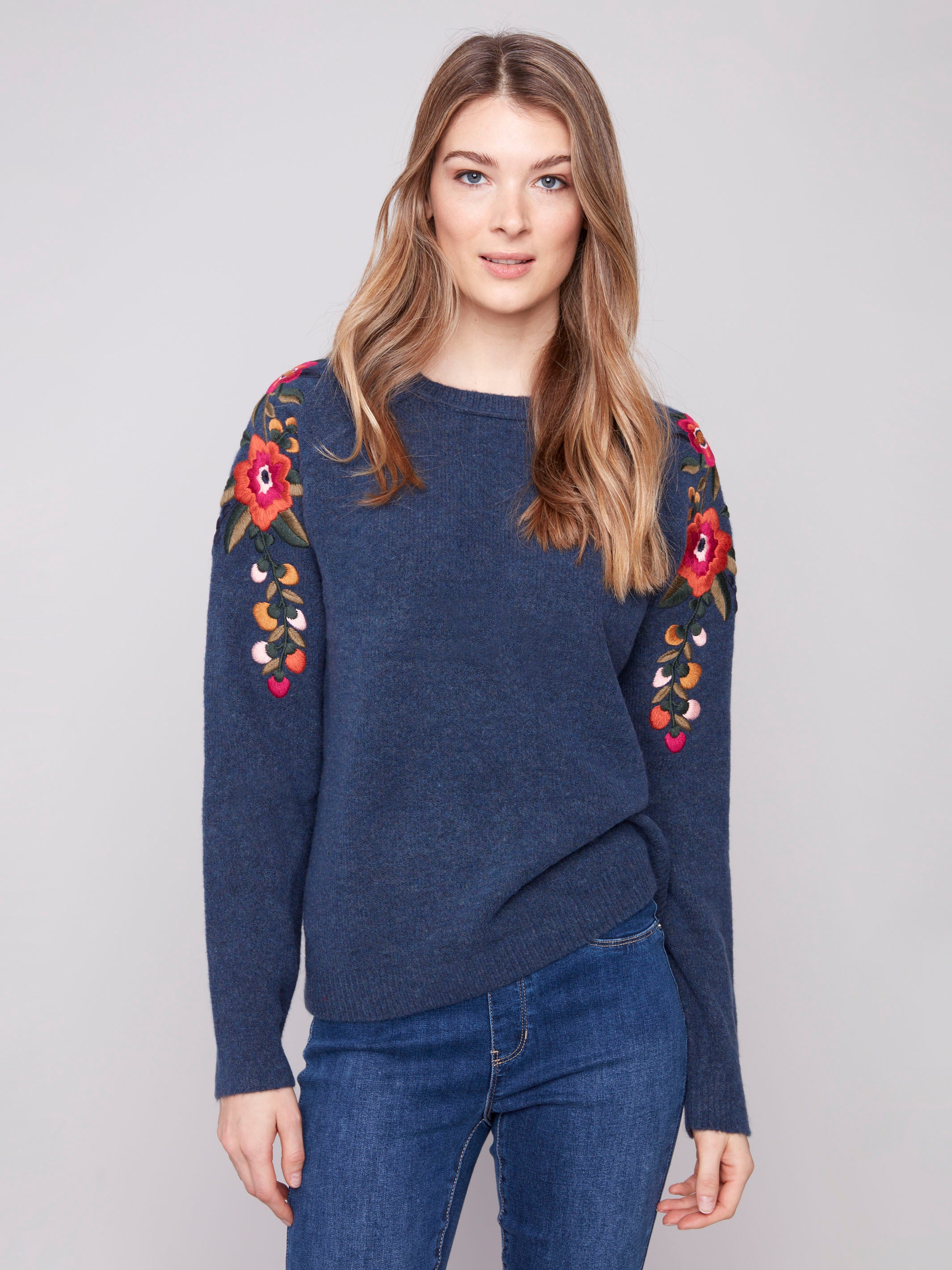Denim sweater with a crew neckline and floral embroidery, adding elegance to casual wear by Charlie B.