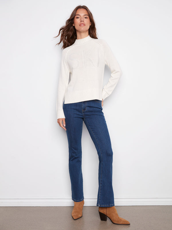 This ecru sweater features subtle metallic detail that enhances its chic look, paired with classic raglan sleeves by Charlie B.