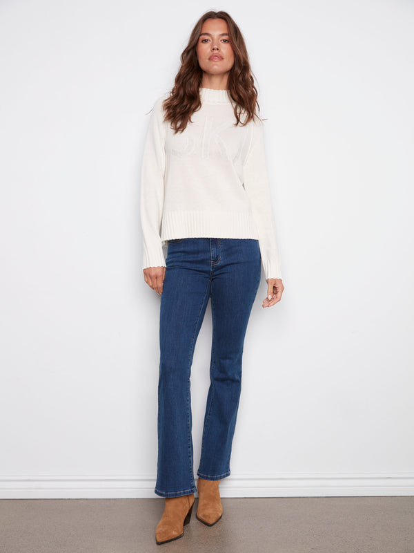 Ecru mock neck sweater with 'SKI' graphic and subtle metallic details adds elegance to your winter style by Charlie B.