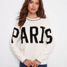 White sweater featuring a classic crew neck and 'PARIS' boucle embroidery, perfect for casual outings by Charlie B.