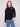 Elegant black sweater with a chic mock neck, paired with casual blue jeans for a stylish look by Charlie B.