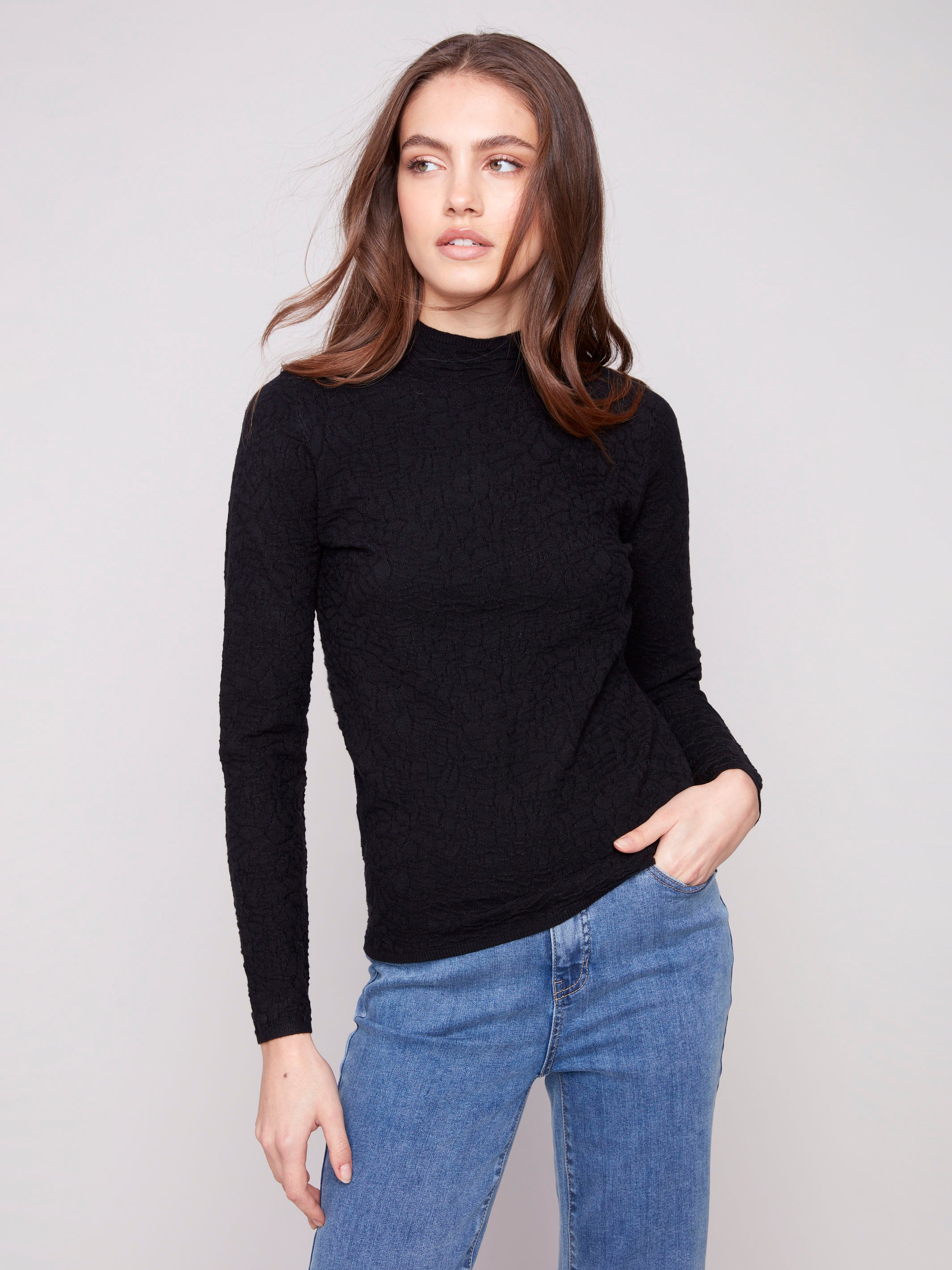 Sophisticated black sweater featuring textured fabric, perfectly matched with blue jeans by Charlie B.