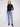 Stylish ensemble showcasing a slim fit black sweater and blue jeans, creating a sleek silhouette by Charlie B.