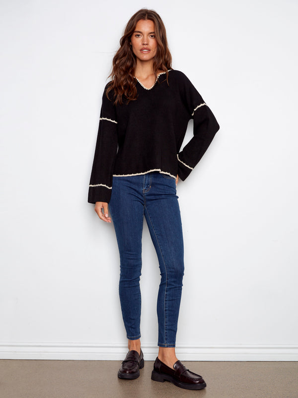 Chic black sweater showcasing an embroidered back design and relaxed fit for casual elegance by Charlie B.
