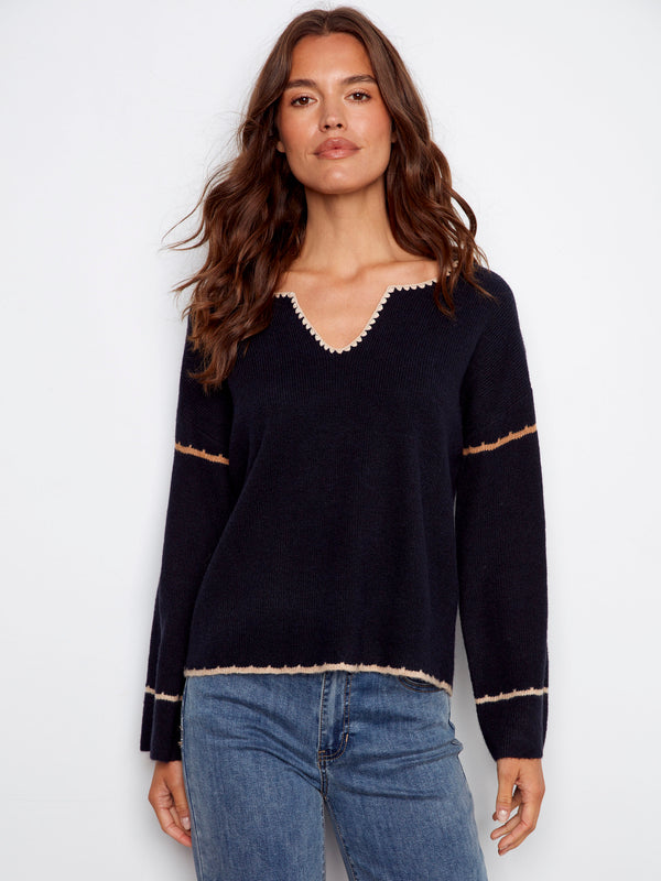 Navy sweater with drop shoulders and delicate white trim detail, creating a casual yet stylish look by Charlie B.