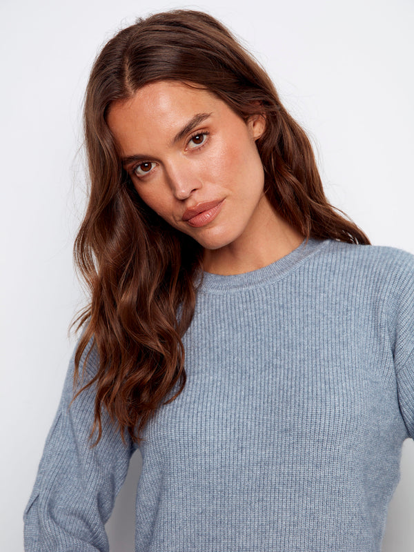 Elegant heather denim sweater showcasing unique cable detailing on sleeves by Charlie B.