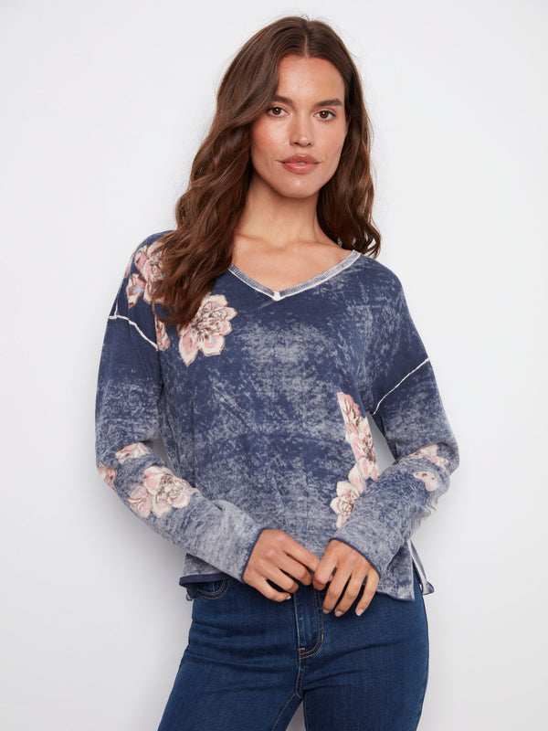 V-neck denim blue sweater highlighted with a relaxed fit and charming floral prints by Charlie B.