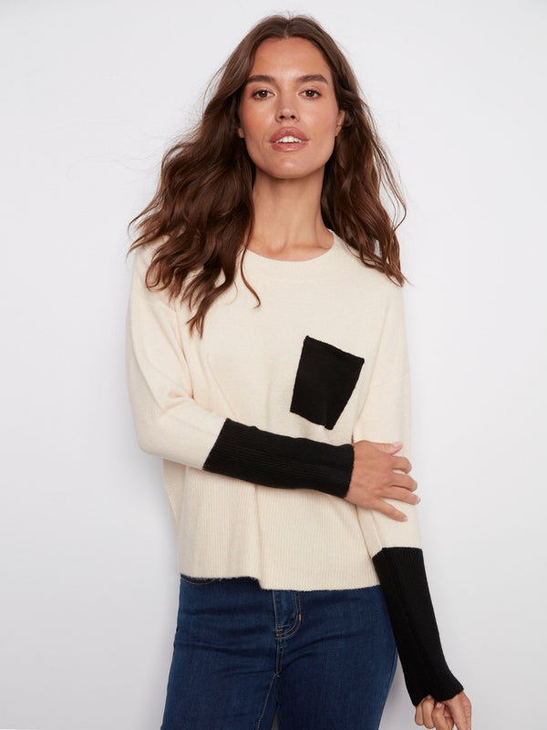 Chic ecru sweater accentuated with a bold black chest pocket, perfect for versatile styling by Charlie B.