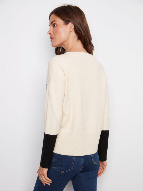 Sophisticated ecru sweater highlighted by its unique contrast black pocket and cozy long sleeves by Charlie B.