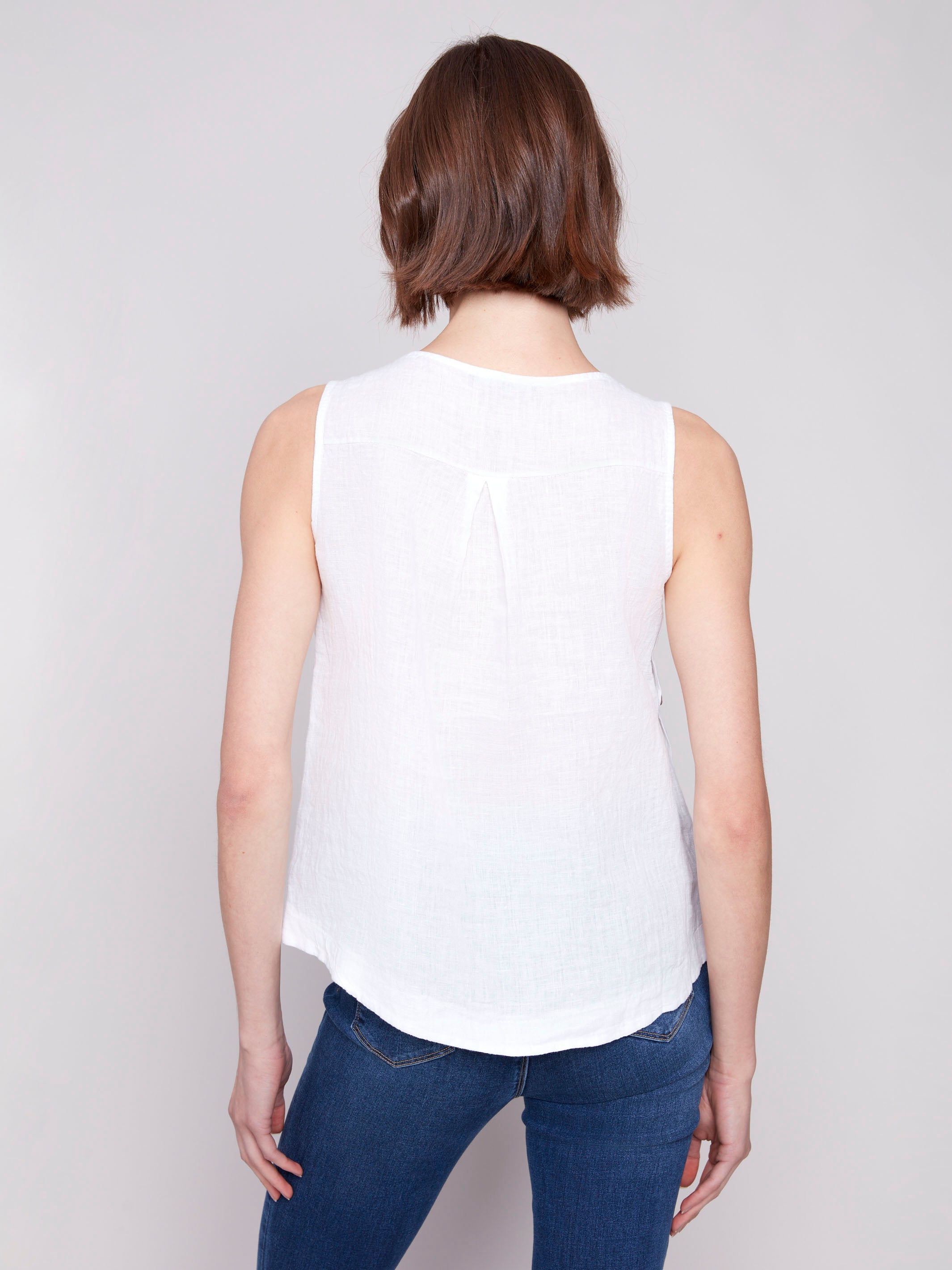 Chic sleeveless design on a white linen top by Charlie B.