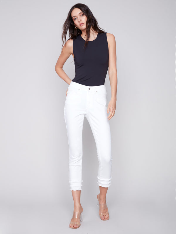 White cropped trousers designed with five pockets and frayed hems for added flair by Charlie B.