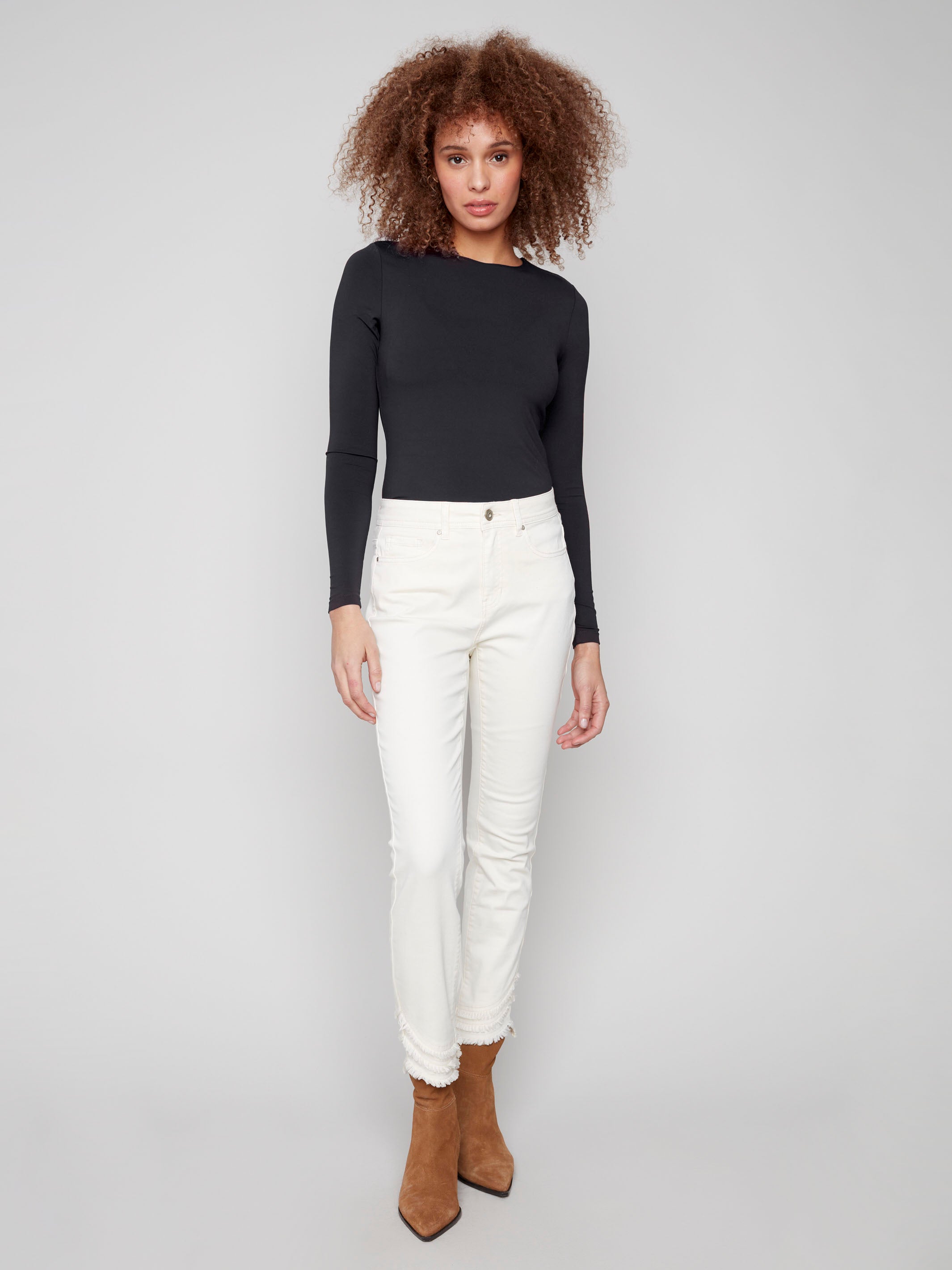 Stretch denim skinny pants with a regular rise waist and chic frayed hem detail by Charlie B.