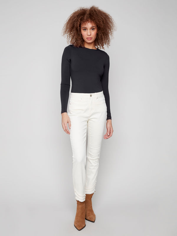 Stretch denim skinny pants with a regular rise waist and chic frayed hem detail by Charlie B.