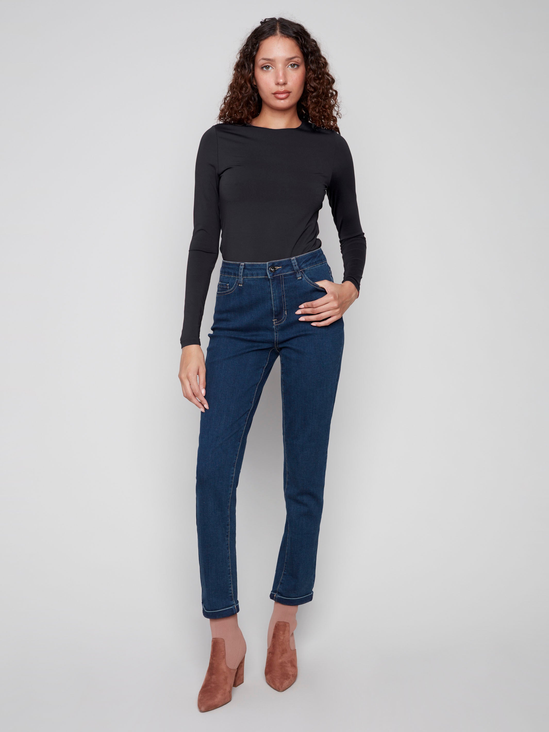 Dark blue slim leg jeans with a cuffed hem, featuring a classic five-pocket design and button closure by Charlie B.