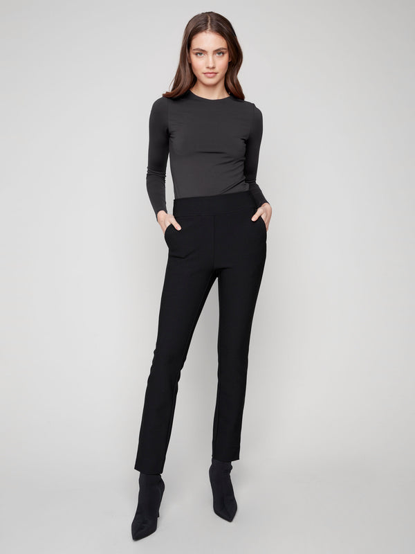 Black slim-fit dress pants with a comfortable elastic waistband and two back welt pockets, ideal for any occasion by Charlie B.